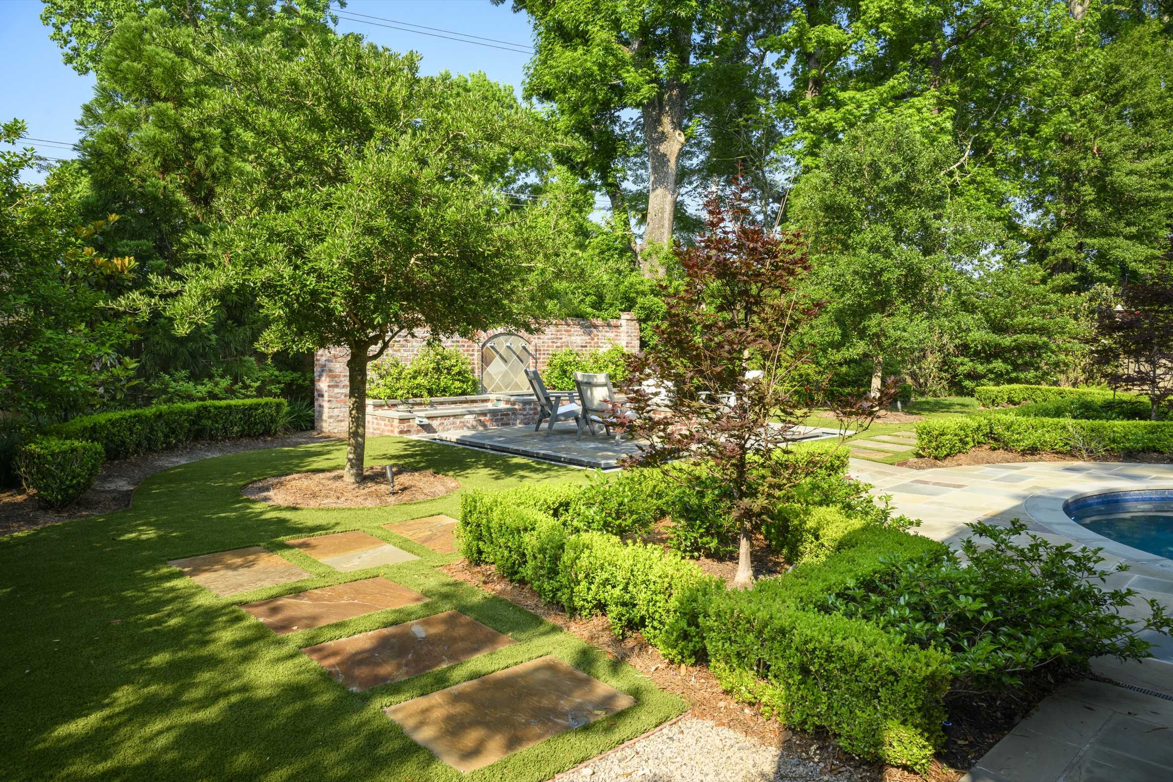 Sunken garden with stone steppers and fountain alcove