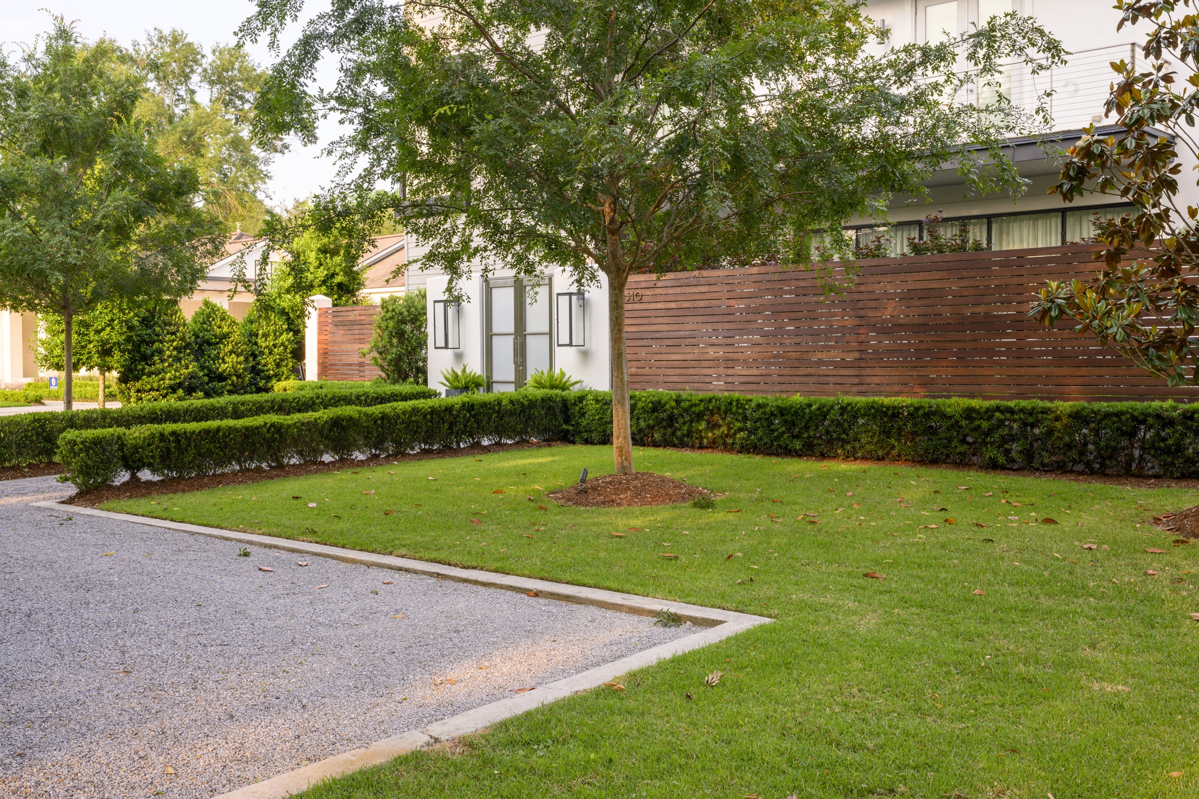 Lawn panel and hedge row along the slat fence