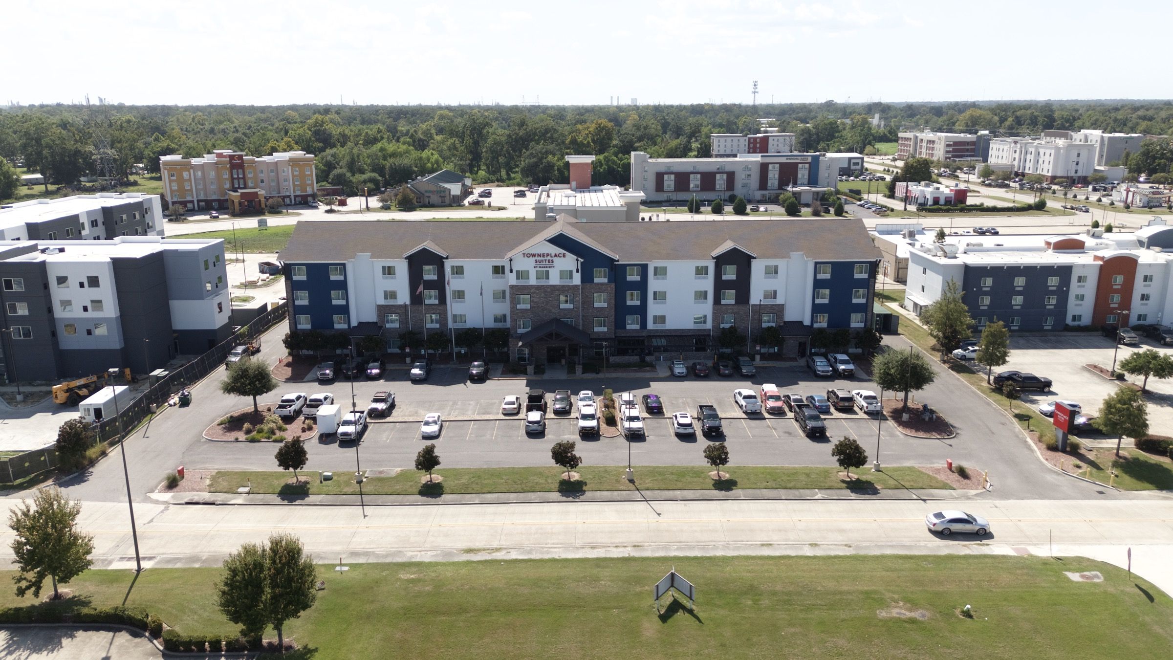 TownePlace Suites, aerial view of the hotel, parking lot tree islands, and street lawn